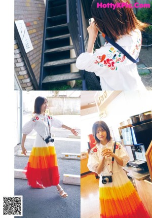 A woman standing in front of a window wearing a colorful shirt.