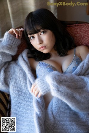 A woman in a plaid shirt and blue panties posing for a picture.