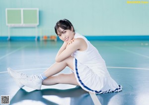 A woman sitting on top of a wooden bench.