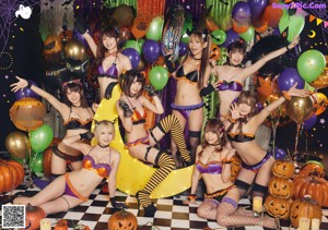 A group of girls dressed up in halloween costumes posing for a picture.