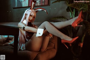 A woman in a bunny costume sitting on a couch.