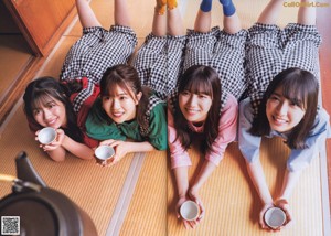 A group of young people sitting on top of a bed.