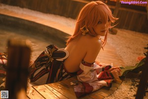 A woman in a kimono sitting in a hot tub.