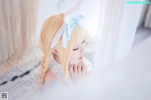 A girl in a blue and white dress with bunny ears.
