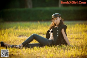 A woman in overalls and a hat is posing for a picture.