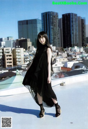 A woman in a white shirt and skirt posing for a picture.