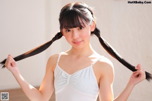 A young woman in a white and blue dress is dancing.