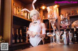 A woman in a bunny costume sitting on a bar.