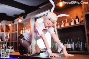 A woman in a bunny costume holding a stuffed animal.