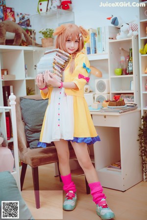 A woman sitting on a chair in front of a bookshelf.