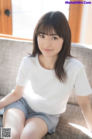 A woman in a blue sweater leaning on a wooden table.