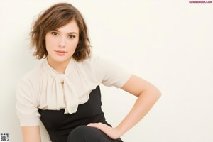 A woman in a black dress posing for a picture.