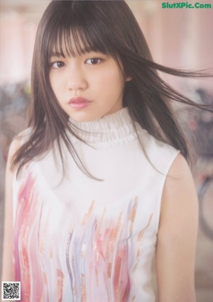 A young woman with long black hair and bangs posing for a picture.