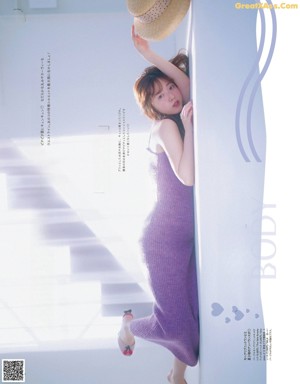 A magazine spread with a woman doing a handstand on a bed.