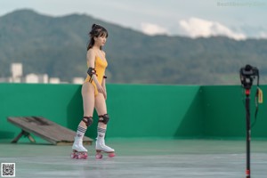 A woman in a yellow bathing suit on roller skates.