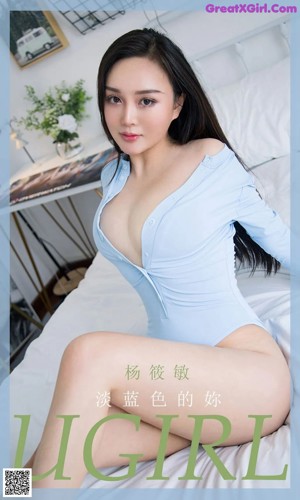 A woman in a blue bodysuit sitting on a bed.