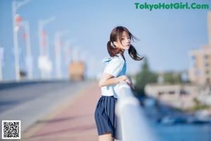 A woman in a blue shirt and black skirt posing for a picture.