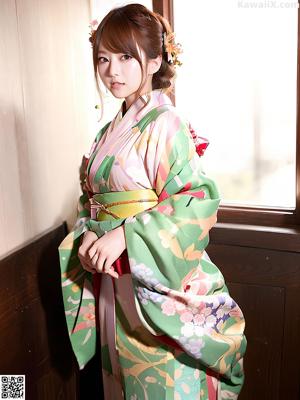 A woman in a kimono sitting on a window sill.