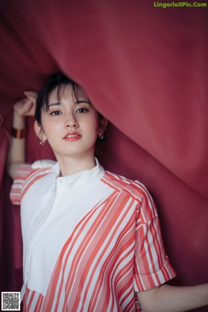 A woman in a pink sweater leaning against a door.