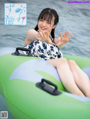 A woman in a bathing suit is splashing in the water.