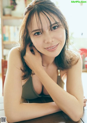 A woman in a green bikini sitting on the floor.