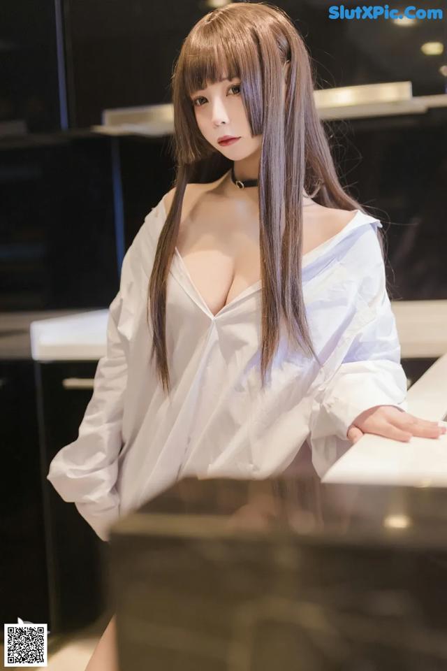 A woman in a white shirt is posing for a picture.