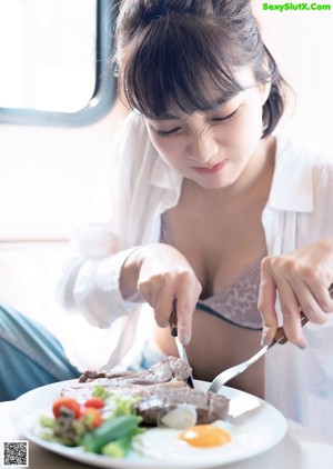 A woman sitting at a table with a plate of food.