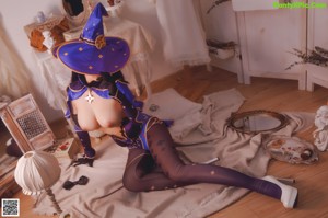 A naked woman dressed as a witch sitting on a table.