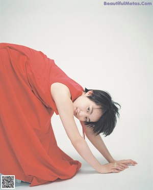 A woman wearing a white top and blue skirt.